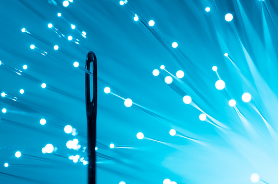Blue Light illuminated fiber optics through eye of needle close-up view