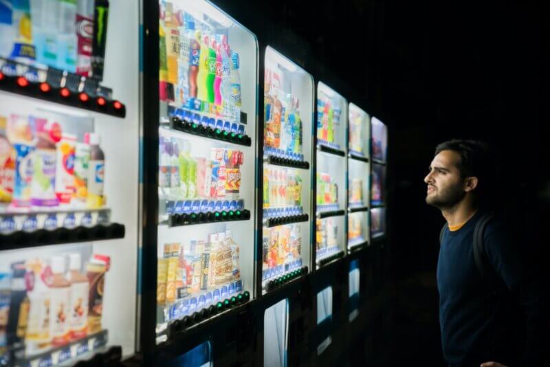 man looking at beverages in supermarket.