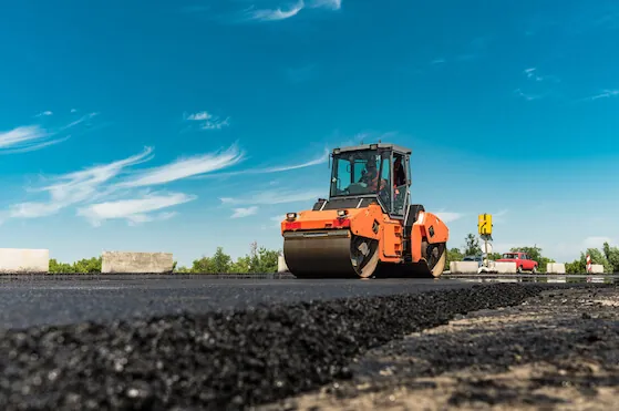 Roller rolling fresh hot asphalt on the new road. Accurate climate weather helps planning ahead of constructions.